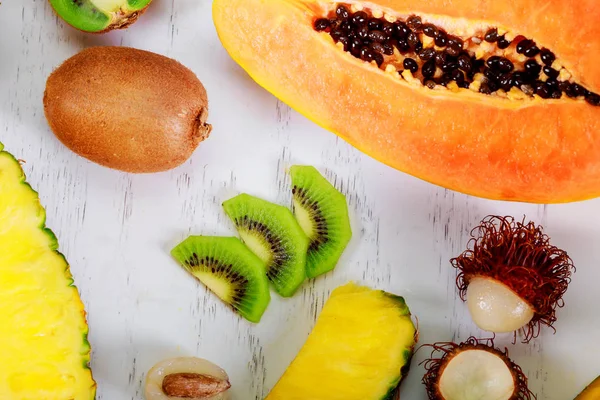 Egzotik meyveler yaz bir tropikal kompozisyon papaya, Kamkat, hranadylla, tutku meyve, Beyaz ahşap zemin