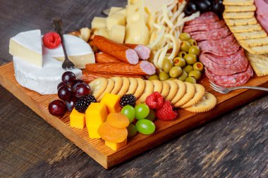 Lezzetli taze çeşitli peynir, çilek, incir, fındık, meyve ve zeytin rustik ahşap masa arka plan üzerinde ile ayrıntılarını