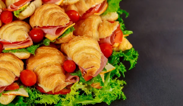 Tasty breakfast. Appetizing croissant with salami and cheese, tomatoes