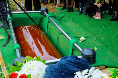 People at funeral putting down the coffin at a funeral clipart