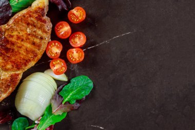 Lezzetli domuz biftek taş zemin üzerine otlar ile yakın çekim