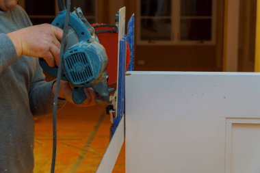 İşçi elektrik daire testere kesme kapı profil sanayi üretimi kapatın elinde tutuyor.