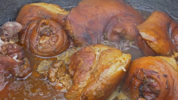 geschmorte Schweinshaxe mit Kräutersuppe, die im Kochtopf kocht