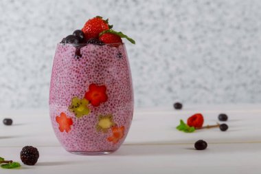 Chia tohum puding ve orman beyaz zemin üzerine bir bardak taze çilek.