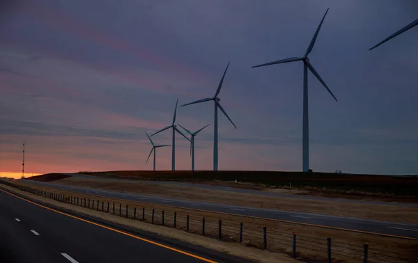 Wind energy blows into West Texas wind turbine farms in the colorful sunset showing renewable energy works