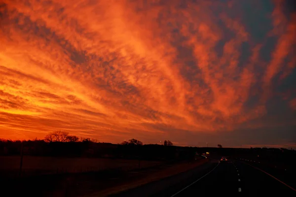 Estrada rural com céu nublado à luz do pôr-do-sol — Fotografia de Stock