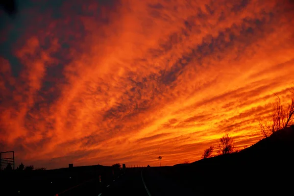 Auto brandt de rijbaan in deze schilderachtige twilight landschap sunset — Stockfoto