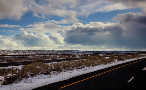 Vista de un camino curvo cubierto de nieve camino durante el invierno, montañas de nieve en la distancia . — Foto de Stock