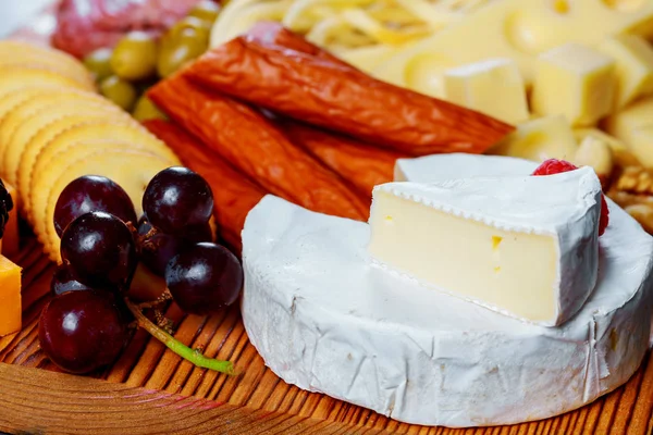 Cheese plate served with crackers, assorted cheeses — Stock Photo, Image