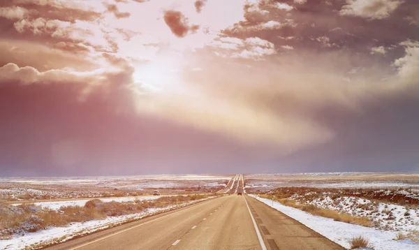 Op zoek naar een lange weg in New Mexico, met sneeuw bergen in de verte — Stockfoto
