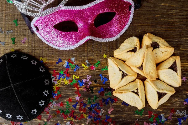 Jewish holiday Purim with carnival mask and hamantaschen cookies. Flat lay