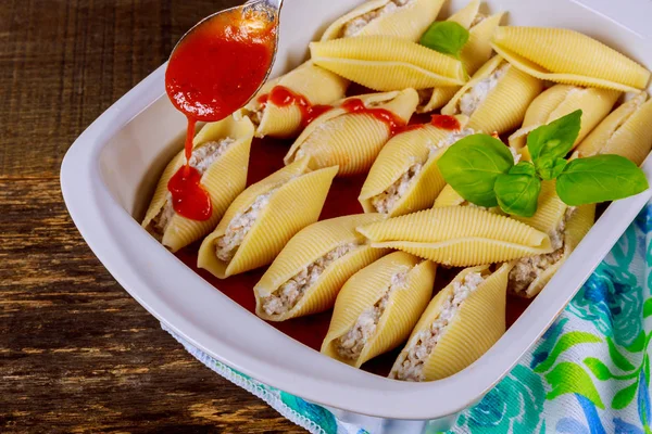 Kaas jumbo pasta schelpen gevuld met marinara saus geserveerd met set op wit — Stockfoto