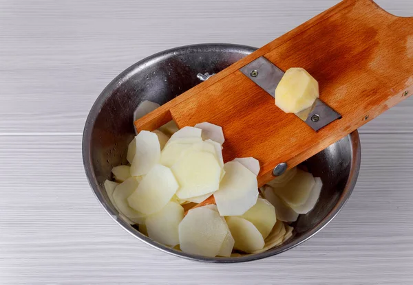 Surowe ziemniaki i fragmentator na podłoże drewniane — Zdjęcie stockowe