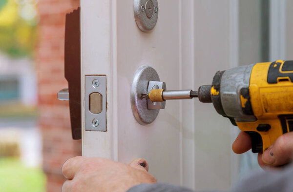 handyman repair the door lock in workers hands installing new door locker