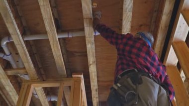 Tesisatçı, yakın plan çekimde plastik tuvalet beyaz borusunu tamir ediyor.