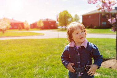 Çocuk dışarıda oynuyor. Sevimli komik çocuk, sarışın sağlıklı yürümeye başlayan kız doğa zevk, ilkbahar yaz bluebells çiçek ağaç oynarken
