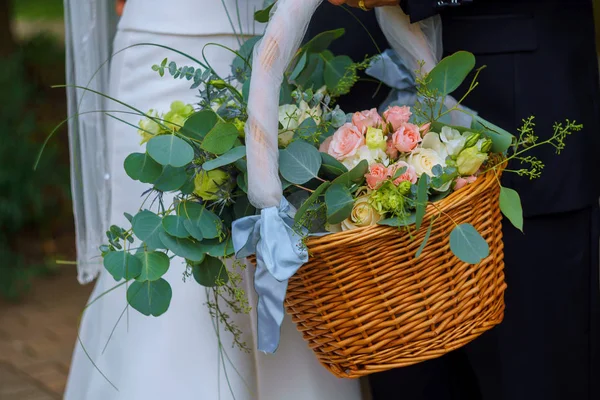 Vrouw in witte jurk met een mand bloemen geen gezicht — Stockfoto