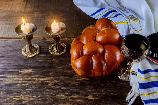 Shabbat eve table candles and cup of wine with covered challah bread, — Stock Photo, Image