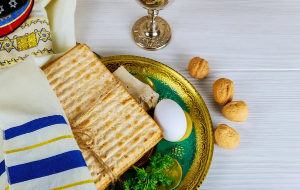 Tisch bereit für das traditionelle Sederteller-Ritual am jüdischen Pessach-Fest. Kiddush-Tasse, Haggada, Matzos, Salat — Stockfoto