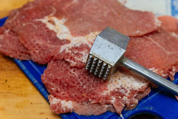 Raw chops on a cutting board and meat hammer — Stock Photo, Image