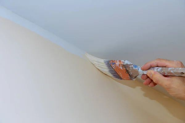 Рука держа кисть живопись цвет к стене угла — стоковое фото