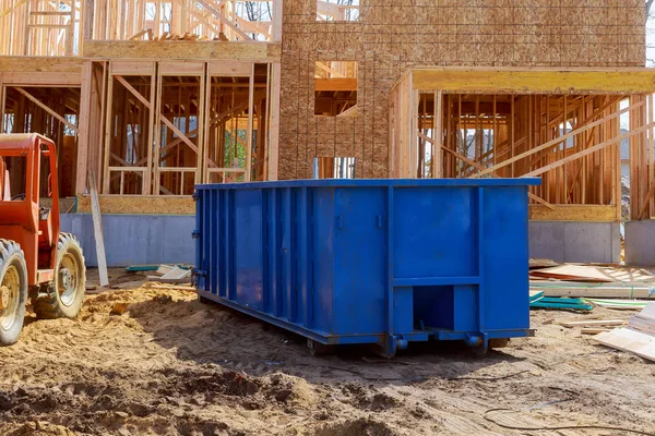 Müllcontainer, Recyclingabfälle und Mülltonnen in der Nähe der neuen Baustelle eines Mehrfamilienhauses — Stockfoto