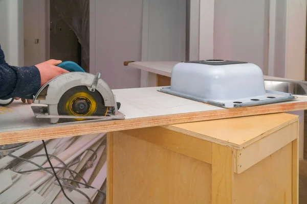 Carpintero instalando un agujero de corte de remodelación en una encimera laminada . — Foto de Stock