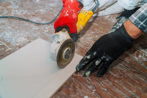 Worker cutting flooring tile with an diamond electric saw blade a construction site — Stock Photo, Image