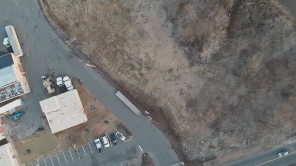 Vista aérea de uma estrada que corre entre a distância e um rio abaixo — Vídeo de Stock