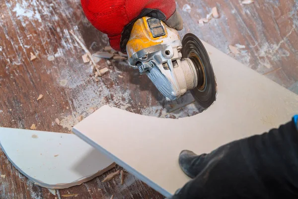Worker using an grinder cutting a floor tile — Stock Photo, Image