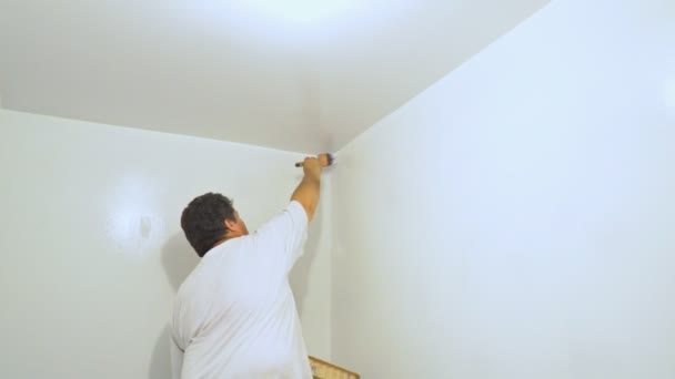Βάψιμο το ταβάνι και τους τοίχους. Ζωγράφος χρησιμοποιεί πινέλο. — Αρχείο Βίντεο