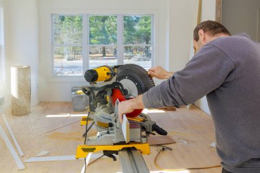 Marangoz, tahta döşemeleri kesmek için testere kullanıyor.