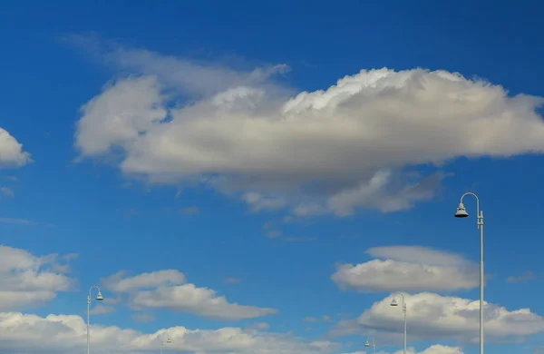 Straßenlaternen leuchten vor blauem Himmel mit Wolken — Stockfoto