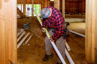 İnşaatta plastik PVC boru özel makas kullanan işçiler