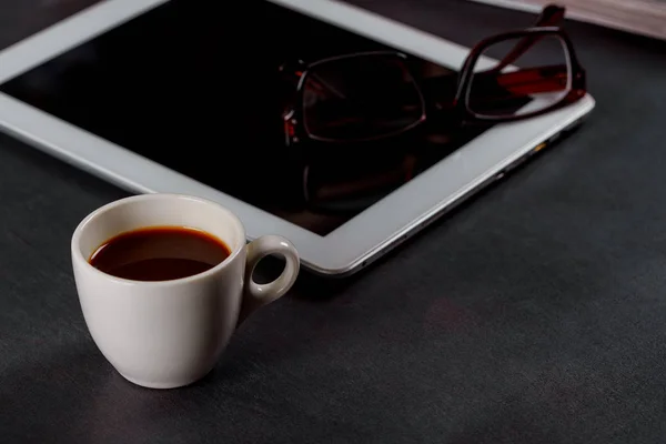 Fehér tabletta számítógép-ra egy fából készült asztal-val egy szemüveg, egy csésze-ból fekete kávé — Stock Fotó