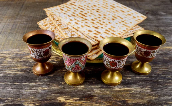 Páscoa matzoh pão feriado judaico, quatro copos kosher vinho sobre mesa de madeira . — Fotografia de Stock