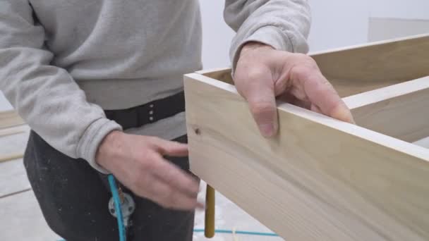 Trabajador Clavos con trabajador utiliza una pistola de clavos para asegurar para una construcción de viviendas — Vídeo de stock