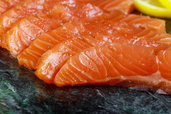 Філе риби невареного лосося з авокадо, на мармуровій тарілці, інгредієнти, готові до їжі — стокове фото