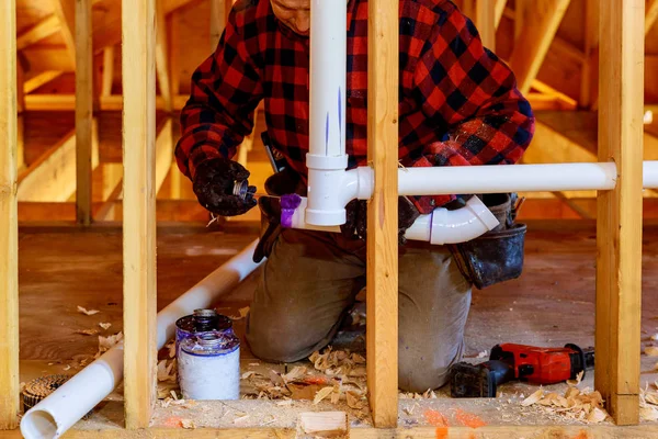 Aplicando o dreno da tubulação do encanador e o sistema de encanamento da ventilação na construção home nova — Fotografia de Stock