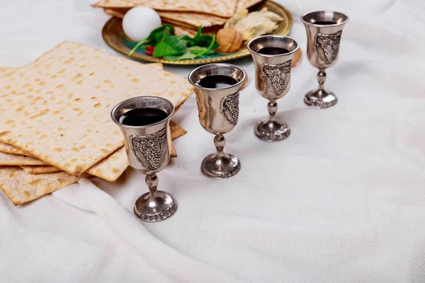 Páscoa matzoh pão feriado judaico, quatro copos kosher vinho sobre mesa de madeira . — Fotografia de Stock