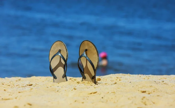 Sandalen-Flip-Flop am weißen Sandstrand mit blauem Ozeanhintergrund im Urlaub — Stockfoto