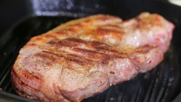 Groot stuk vers varkensvlees bereid op een grill pan. — Stockvideo