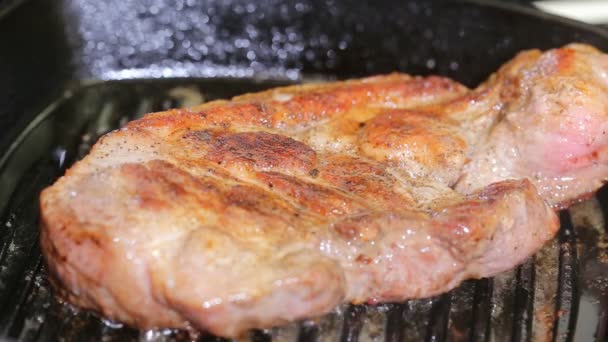 Organic cooked fried pork chop steak meat with on black frying pan close up view — Stock Video