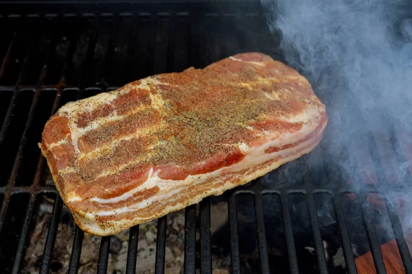 Gegrillter Speck auf Holzkohlegrill im Feuer Speck draußen, Picknick-Konzept. — Stockfoto