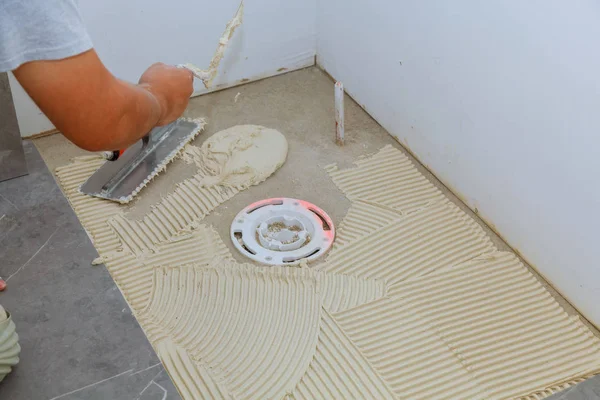 Spreading wet mortar before applying tiles on bathroom floor — Stock Photo, Image