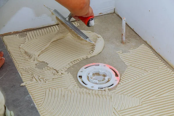 Carrelage et plâtre travaux de réparation pose de carreaux, truelle dans une main d'homme — Photo