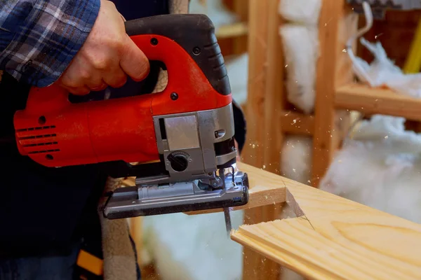 Carpinteiro de corte de serra elétrica cortando um pedaço de madeira — Fotografia de Stock