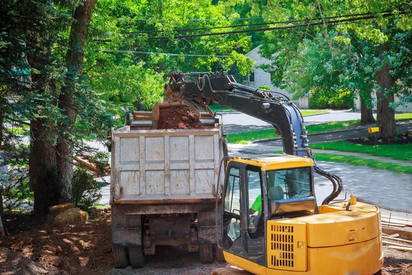 Scavatore giallo grande secchio escavatore raccogliere e versa terreno, pietre in una cava in case di costruzione. In costruzione — Foto Stock