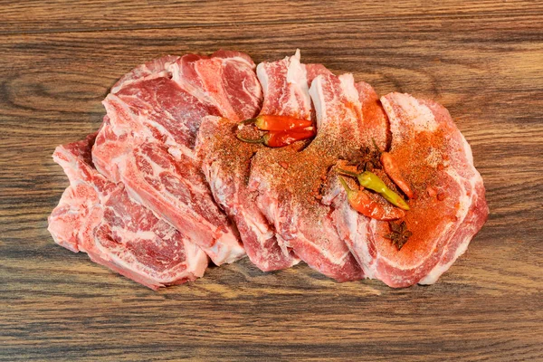 Маринованные свиные стейки на разделочной доске и ингредиенты для приготовления пищи — стоковое фото