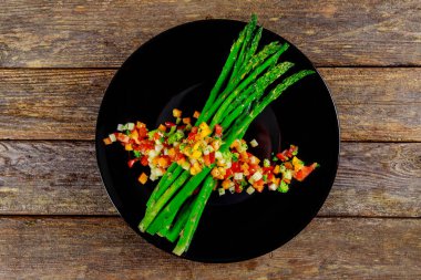 Fırında kuşkonmaz otlar ile domates ile süslenmiş.